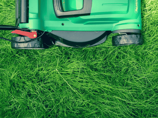 Close-up van een grasmaaier op een groen gazon